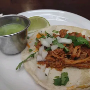 Shredded beef taco with cilantro, onion, salsa verde, and lime from 1st stop