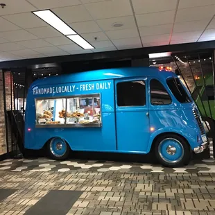 a blue food truck parked in front of a restaurant