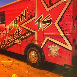 a red food truck parked in a parking lot