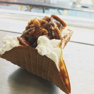 a waffle cone with whipped cream and pecans