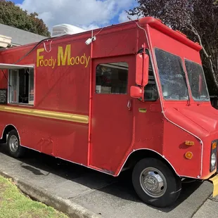 a red food truck parked in a parking lot