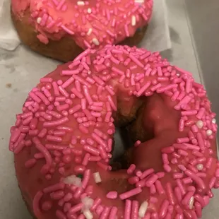 two pink donuts with sprinkles