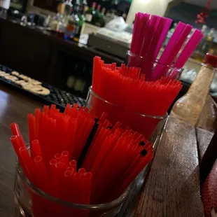 red straws in a glass on a bar counter