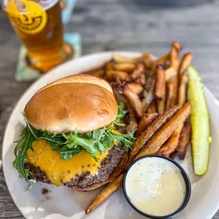 a cheeseburger with fries and a pickle