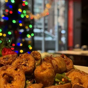 a plate of fried food with a christmas tree in the background