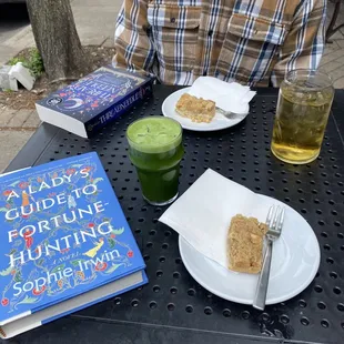 a man sitting at a table with a book and a drink