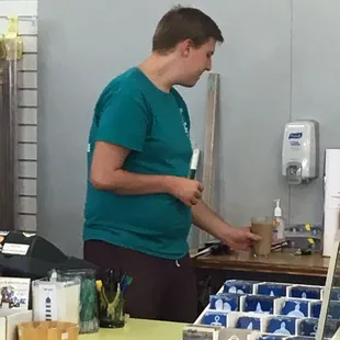 a man in a green shirt standing at a counter