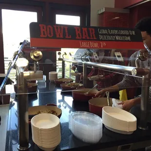 The hot food bar. Large bowls are $7.25 for all-you-can-for from four dishes on each side. Changes every day. Vegan options also