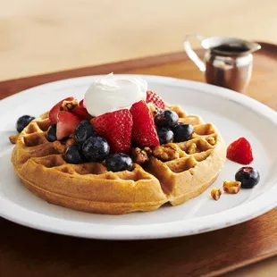 a waffle with berries and whipped cream