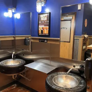 sinks in the men's room showing the unique tire sinks and gas pump handled water spouts.