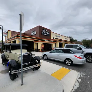 a classic car parked in front of the garage