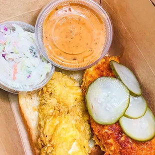 a box of food including a sandwich, coleslaw, and coleslaw