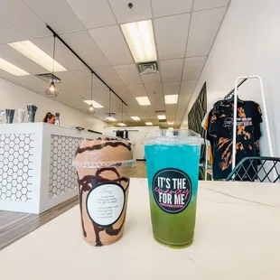 a cup of iced coffee and a beverage on a table