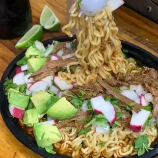 a plate of noodles with meat and vegetables