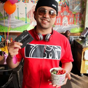 a man holding a bowl of yogurt