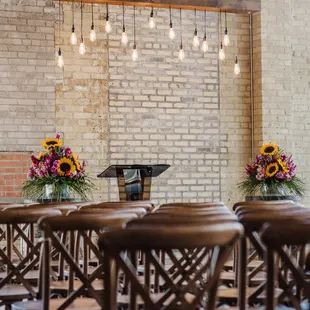 rows of wooden chairs in front of a brick wall
