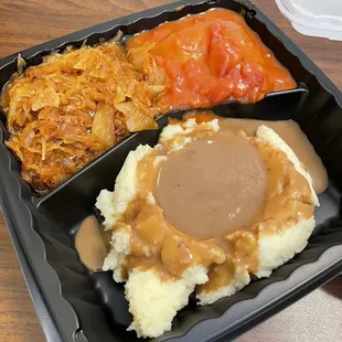 Meal Combo with mashed potatoes and brown gravy, stuffed cabbage and sauerkraut