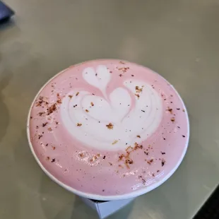 a pink latte with a heart on it