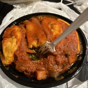 a bowl of stew with a fork in it