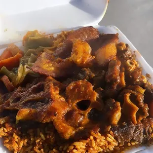 Oxtail stew, jollof rice, steamed veggies, plantains