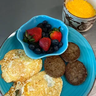 2 egg plate// over easy // 
with sausage, fruit, and cheese grits