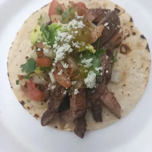 a steak taco on a white plate