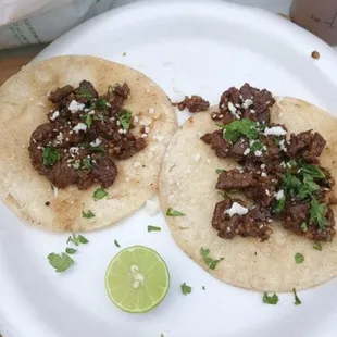 two tacos on a paper plate
