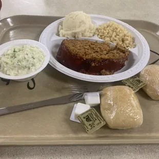 Meatloaf with slaw, corn, mashed potatoes and bread.