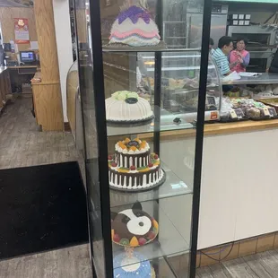 a display of cakes in a glass case