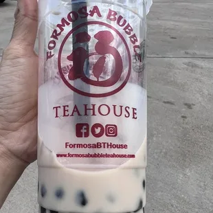 a hand holding a cup of bubble tea