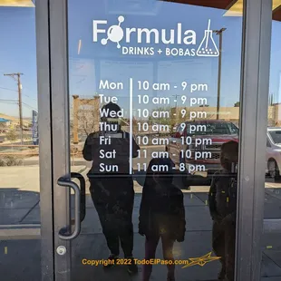a reflection of two people and a dog in a glass door
