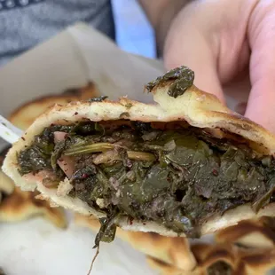 a person holding a piece of food