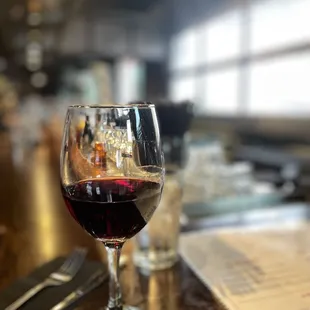 a glass of wine on a bar