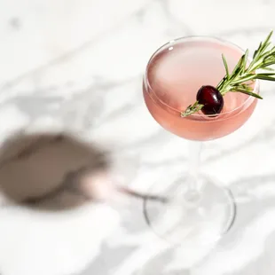 a glass of wine with a sprig of rosemary