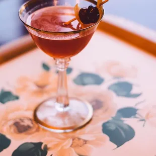 a cocktail in a glass on a tray