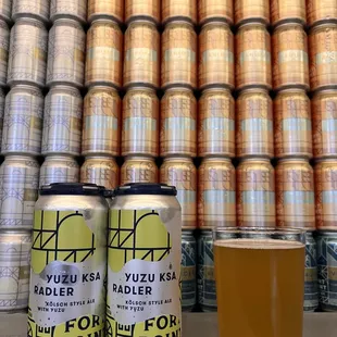 two cans of beer and a glass of beer