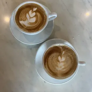 two cups of coffee on a marble table