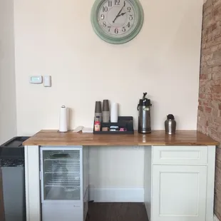 a coffee station with a clock on the wall