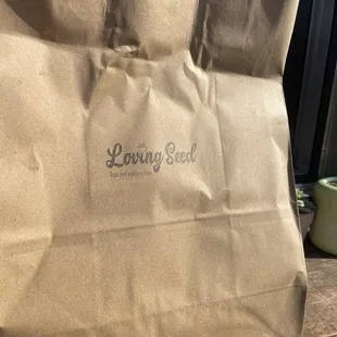a brown paper bag with the loving seed logo