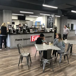people sitting at tables in a coffee shop