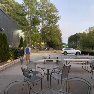 a man walking past tables and chairs