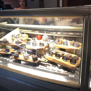 a display case of cheeses and pastries