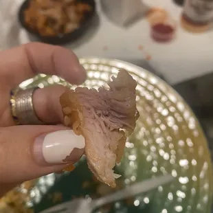 a hand holding a half eaten piece of bread