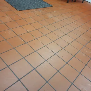 Noodles and rice and dirt and mud all over the floor an tables