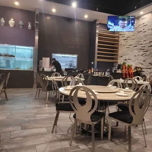 a restaurant with tables, chairs, and a television