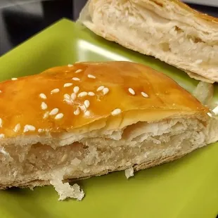 a half eaten sandwich on a green plate