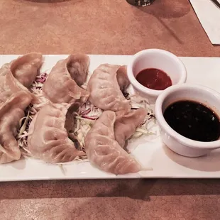 Steamed veggie dumplings with dumpling sauce and sriracha