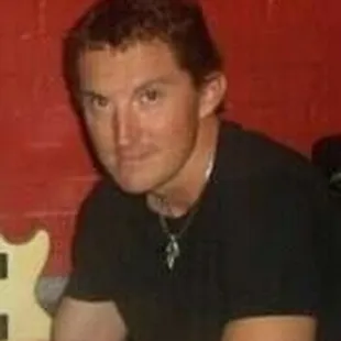 a man sitting in front of a guitar