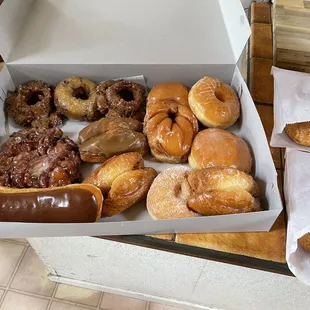 A selection of delicious and fresh donuts, and two croissant sandwiches.