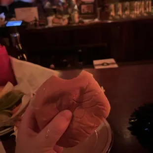 a person holding a donut on a plate